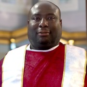 Large smiling man in preacher's robes